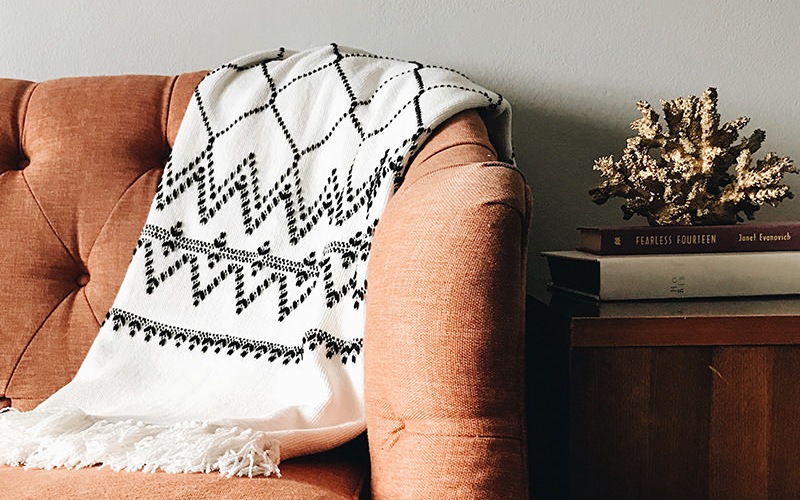 sofa with throw next to decorated side table